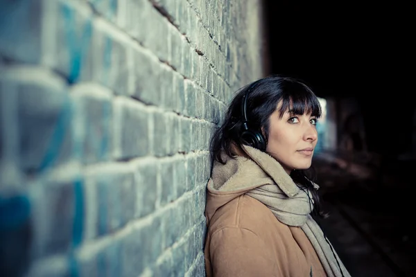 Belle jeune femme écoutant des écouteurs de musique — Photo