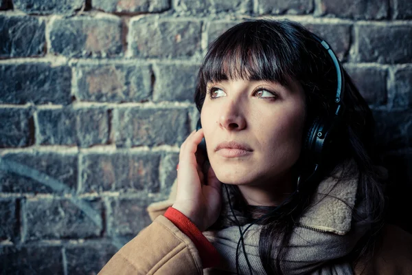 Hermosa mujer joven escuchando música auriculares — Foto de Stock