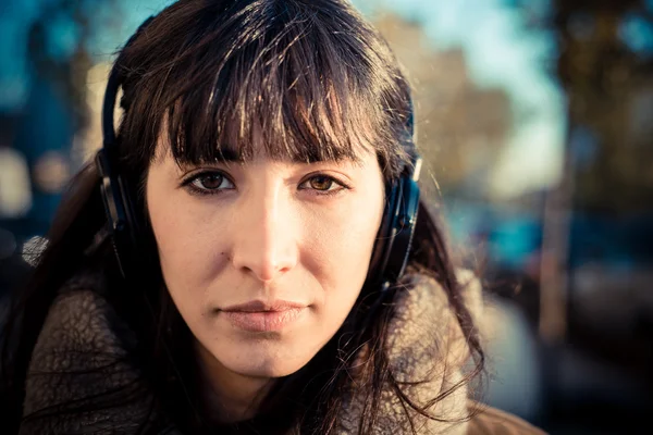 Vacker ung kvinna som lyssnar på musik hörlurar — Stockfoto