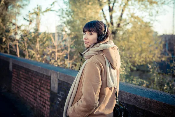 Belle jeune femme écoutant des écouteurs de musique — Photo