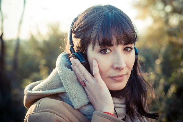 Hermosa mujer joven escuchando música auriculares — Foto de Stock