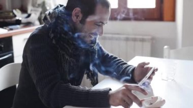 Tablet kullanarak ve sigara genç adam