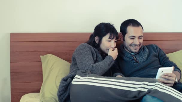 Couple using tablet on the bed at home — Stock Video