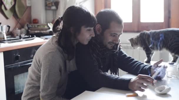 Пара с помощью планшета улыбаясь дома — стоковое видео