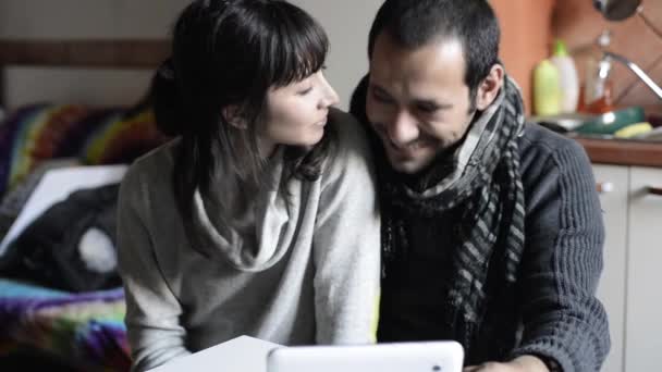 Pareja usando tableta sonriendo y besándose — Vídeos de Stock