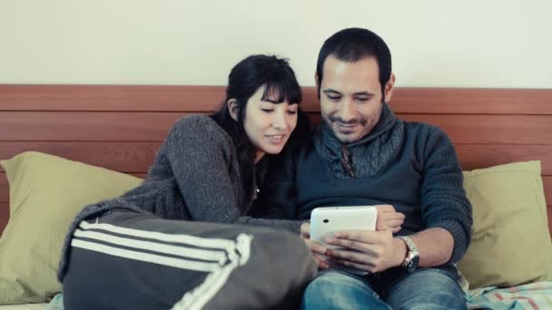 Couple utilisant une tablette sur le lit à la maison — Video