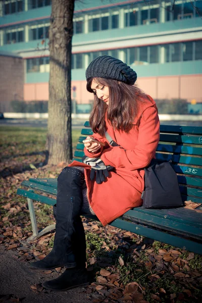 美しい女性の赤いコートの携帯電話 — ストック写真