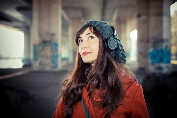 Beautiful woman red coat listening music — Stock Photo, Image