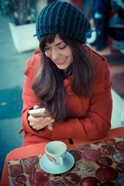 Güzel kadın kırmızı ceket cep telefonu — Stok fotoğraf