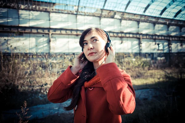 Bela mulher casaco vermelho ouvir música parque — Fotografia de Stock