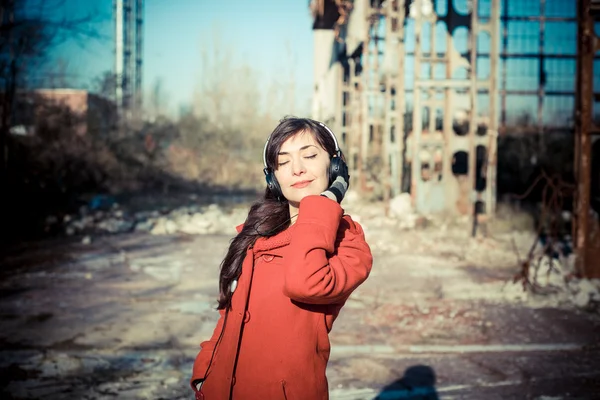 Hermosa mujer rojo abrigo escuchar música parque — Foto de Stock