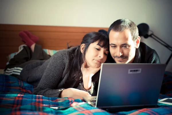 Paar verliefd op het bed met laptop — Stockfoto