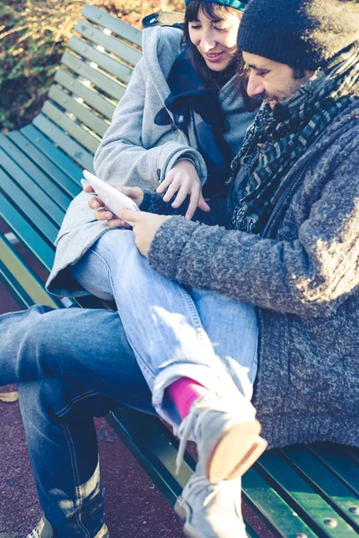 Casal apaixonado usando tablet no parque — Fotografia de Stock
