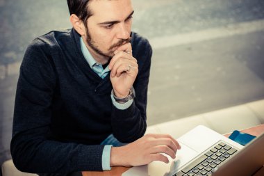 multitasking man met behulp van Tablet PC, laptop- en cellhpone