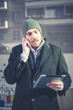 multitasking man met behulp van Tablet PC, laptop- en cellhpone