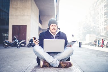 multitasking man met behulp van Tablet PC, laptop- en cellhpone
