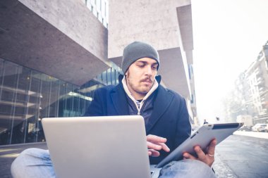 multitasking man met behulp van Tablet PC, laptop- en cellhpone