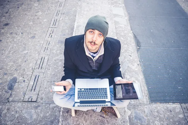 Multitasking man met behulp van Tablet PC, laptop- en cellhpone — Stockfoto