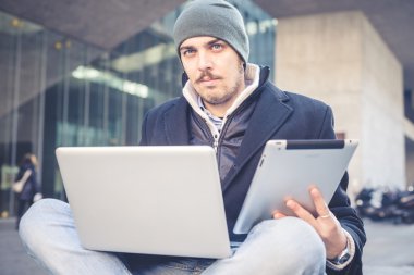 multitasking man met behulp van Tablet PC, laptop- en cellhpone