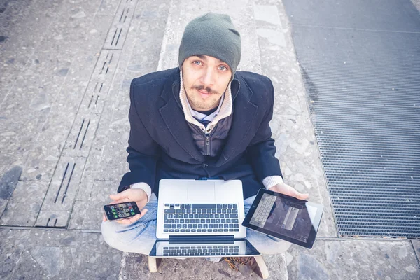 Hombre multitarea utilizando tableta, portátil y cellhpone — Foto de Stock