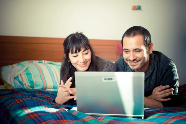 Couple amoureux sur le lit en utilisant un ordinateur portable — Photo