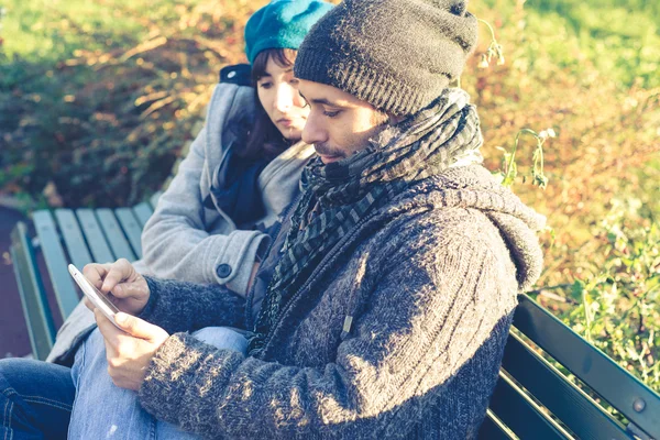 Paar in liefde met behulp van Tablet PC in het park — Stockfoto