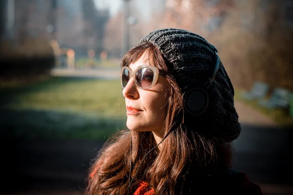 Hermosa mujer rojo abrigo escuchar música — Foto de Stock