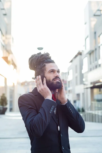 Stijlvolle elegante dreadlocks zakenman luisteren naar muziek — Stockfoto