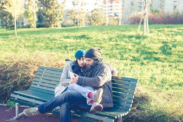 Pareja enamorada usando tableta en el parque — Foto de Stock