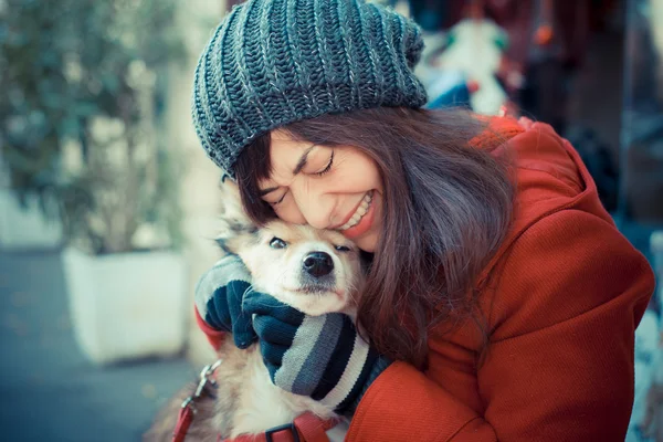 Güzel kadın kırmızı ceket köpek sarılma — Stok fotoğraf