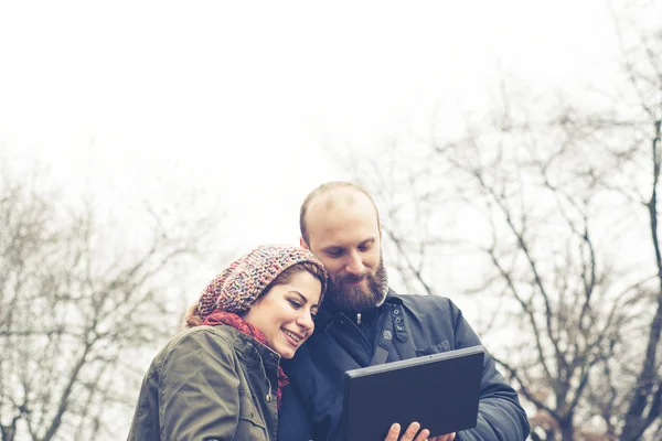 Par i kärlek med hjälp av Tablet PC ansluter web trådlös wifi — Stockfoto