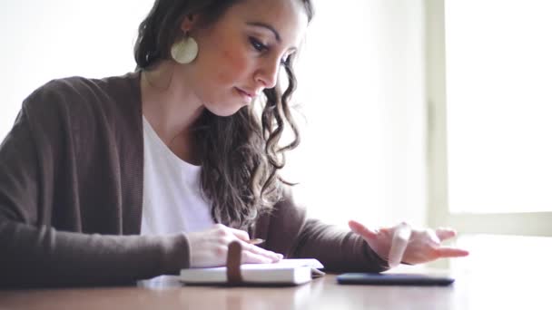 Mulher usando celular e blocknote — Vídeo de Stock