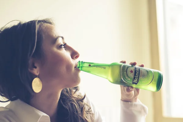 Mulher bebendo garrafa de cerveja heineken 33 cl — Fotografia de Stock