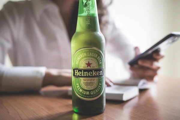 Mulher bebendo garrafa de cerveja heineken 33 cl — Fotografia de Stock