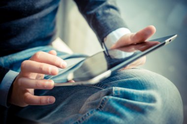 close up hands multitasking man using tablet, laptop and cellhpo clipart