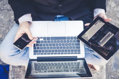 multitasking man met behulp van Tablet PC, laptop- en cellhpone