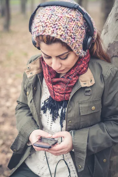 Beautiful brunette woman listening to music with headphones — Stock Photo, Image