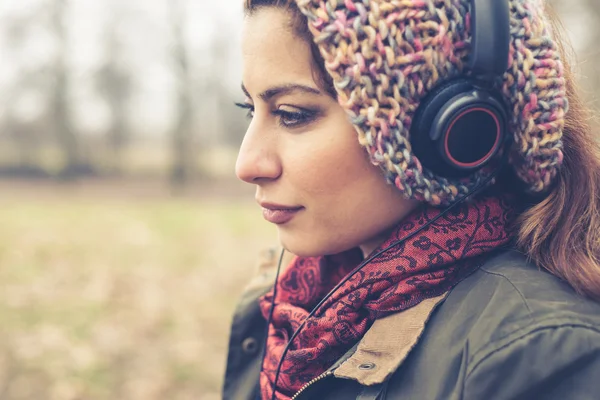 Vacker brunett kvinna lyssna på musik med hörlurar — Stockfoto