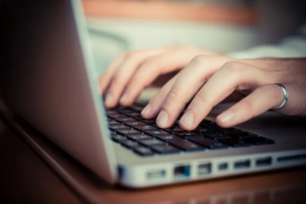 Közelről kezek multitasking ember tabletta, a laptop és a cellhpo használata — Stock Fotó