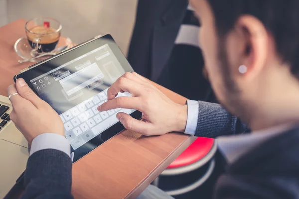 Multitasking man met behulp van Tablet PC, laptop- en cellhpone — Stockfoto