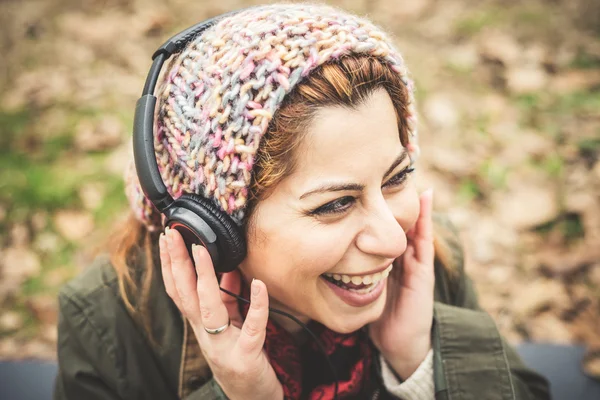 Vacker brunett kvinna lyssna på musik med hörlurar — Stockfoto