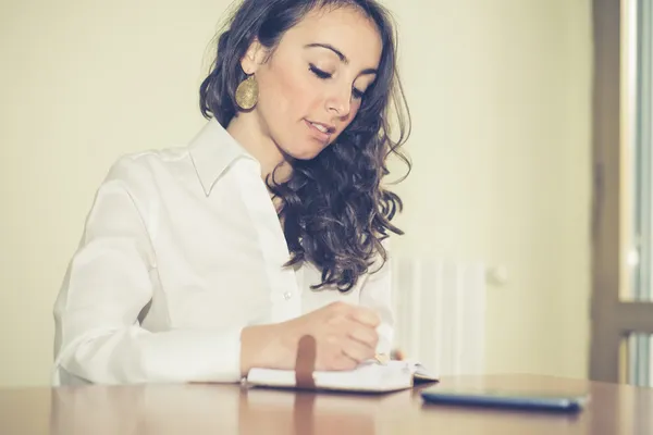 Schöne Frau zu Hause, die schreibt und arbeitet — Stockfoto