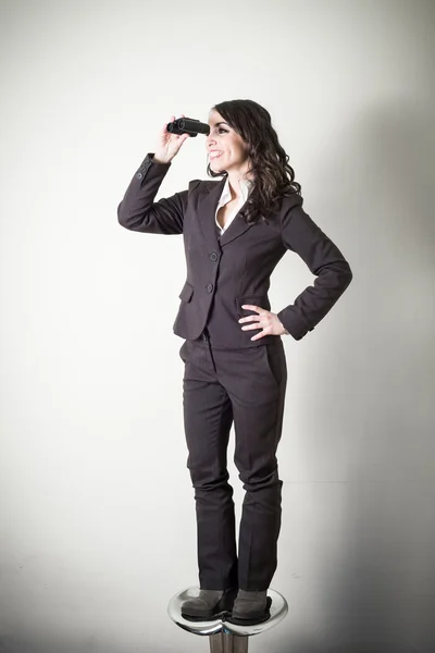 Beautiful young businesswoman with binocular — Stock Photo, Image