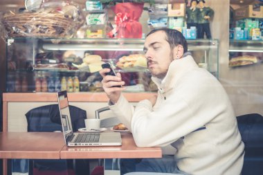multitasking man met behulp van Tablet PC, laptop- en cellhpone