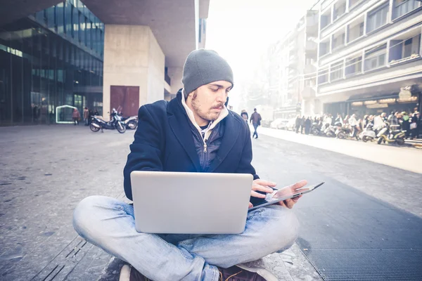 Multitasking man använder Tablet PC, laptop och cellhpone — Stockfoto