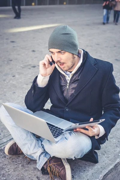 Multitasking man använder Tablet PC, laptop och cellhpone — Stockfoto