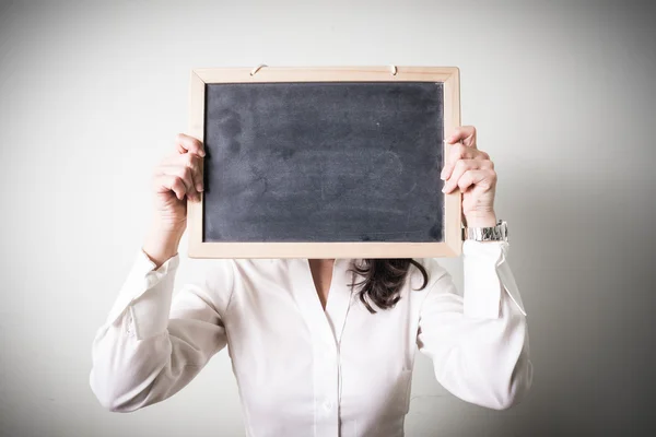 Beautiful young businesswoman holding blackboar — Stock Photo, Image