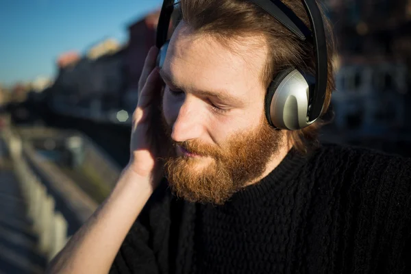 Skäggig man lyssnar musik — Stockfoto