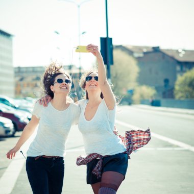 iki kadın akıllı telefon kullanma