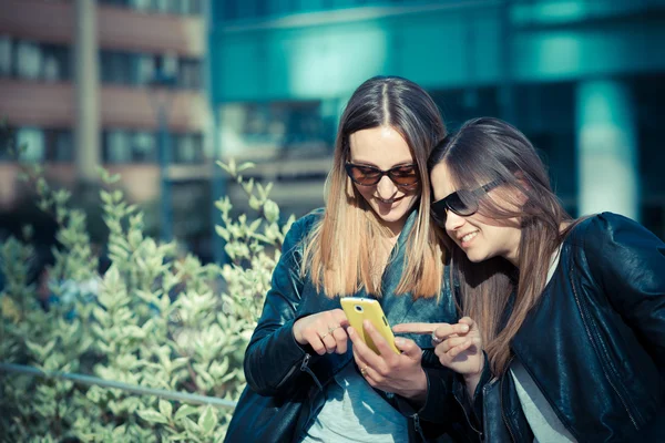 Two women using smartphone — Zdjęcie stockowe